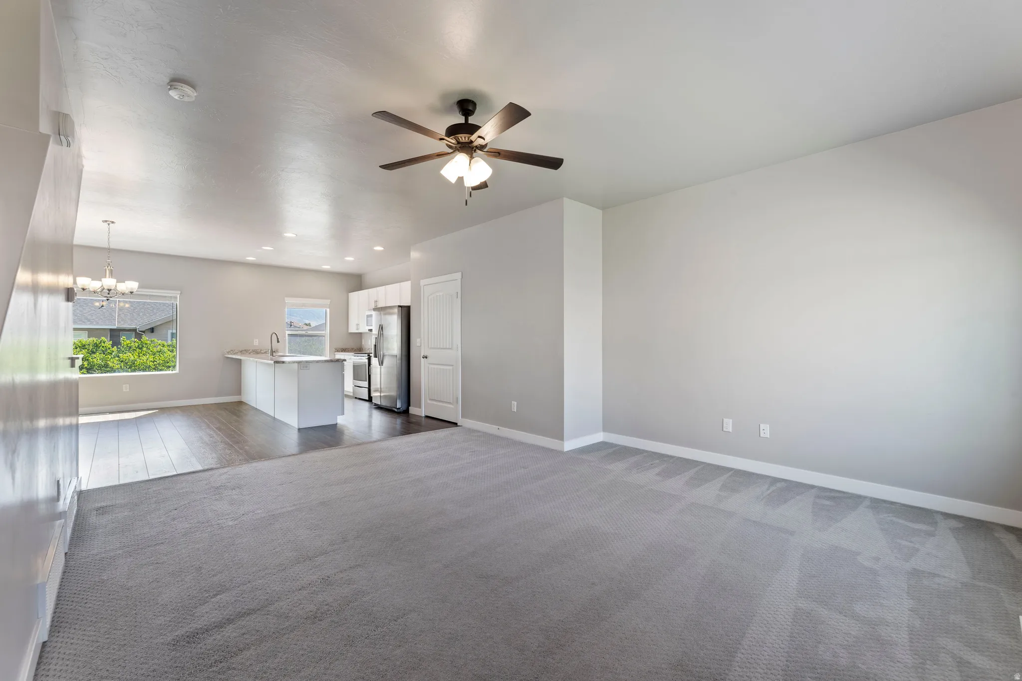 Open-concept living area featuring a ceiling fan with integrated lighting, recessed lighting, and light gray wall paint