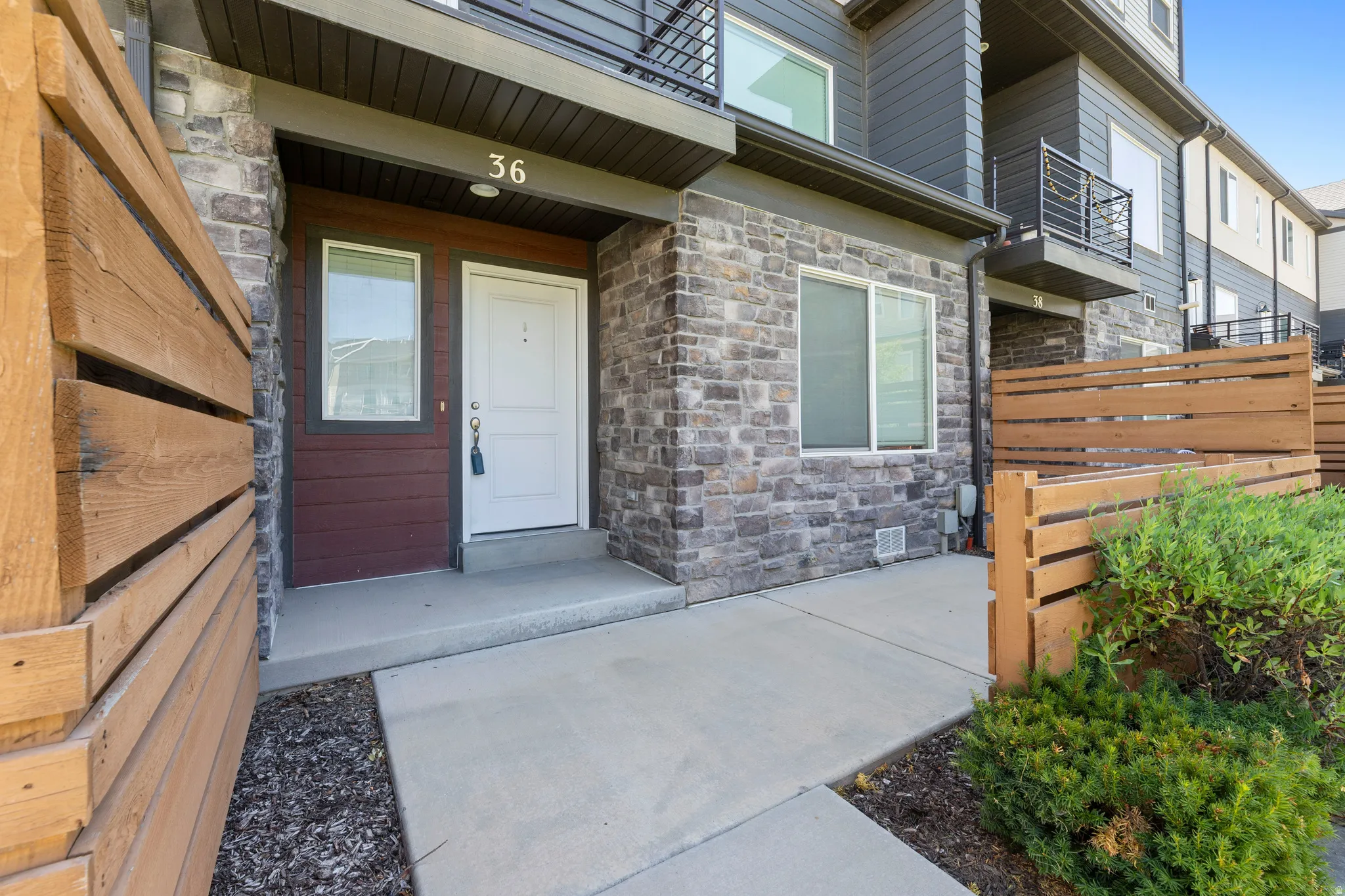 Contemporary townhouse entrance featuring stone veneer and horizontal siding