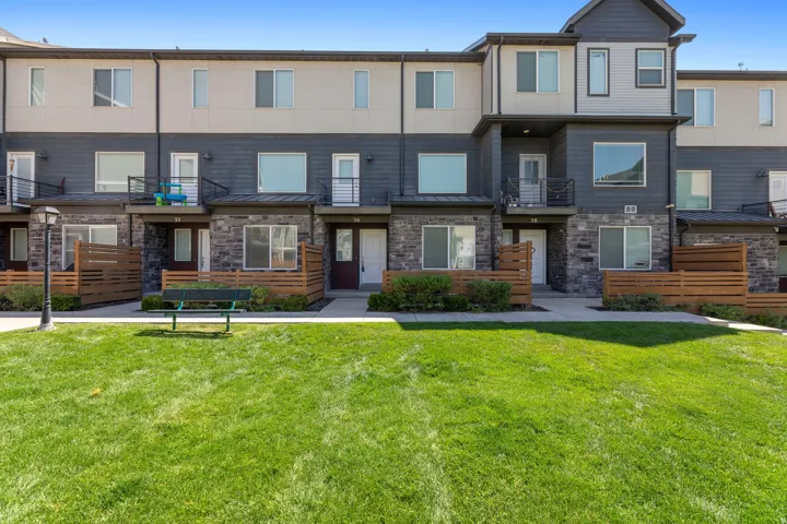 Contemporary multi-story townhome with stone facade accents and horizontal siding