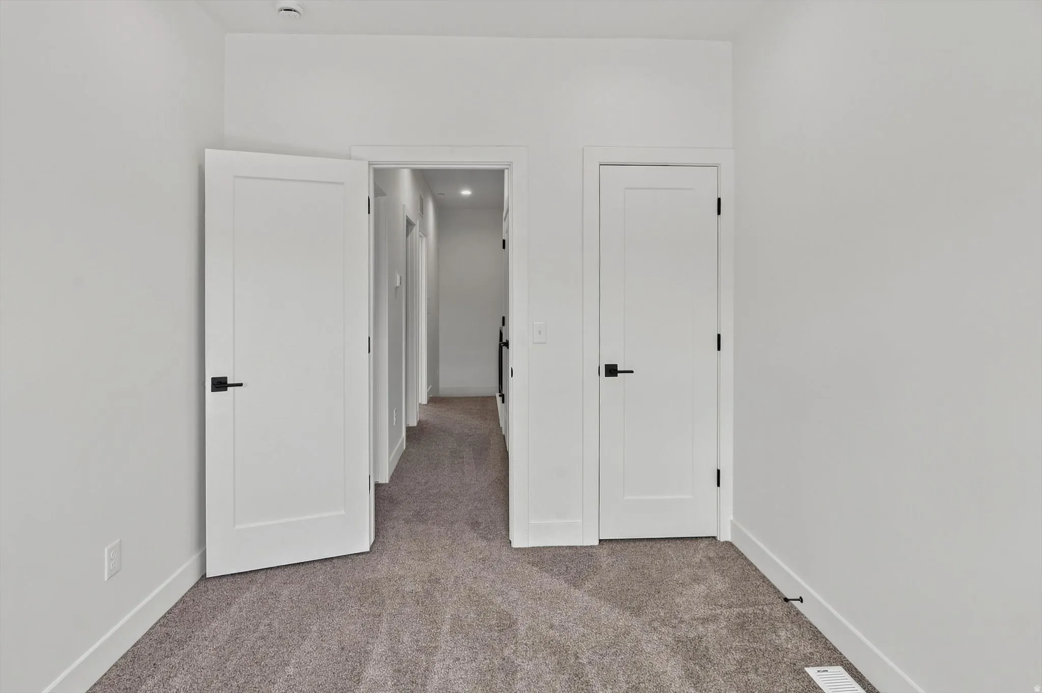 Carpeted interior space featuring white walls and white trim