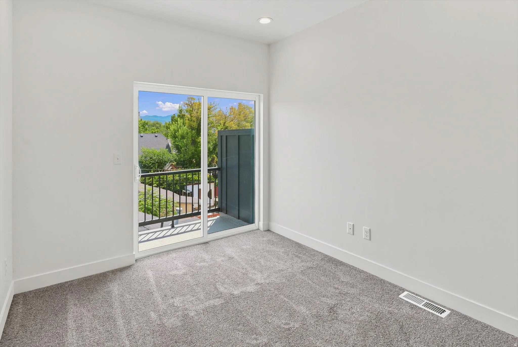 Sliding glass doors opening to an exterior balcony with black metal railings