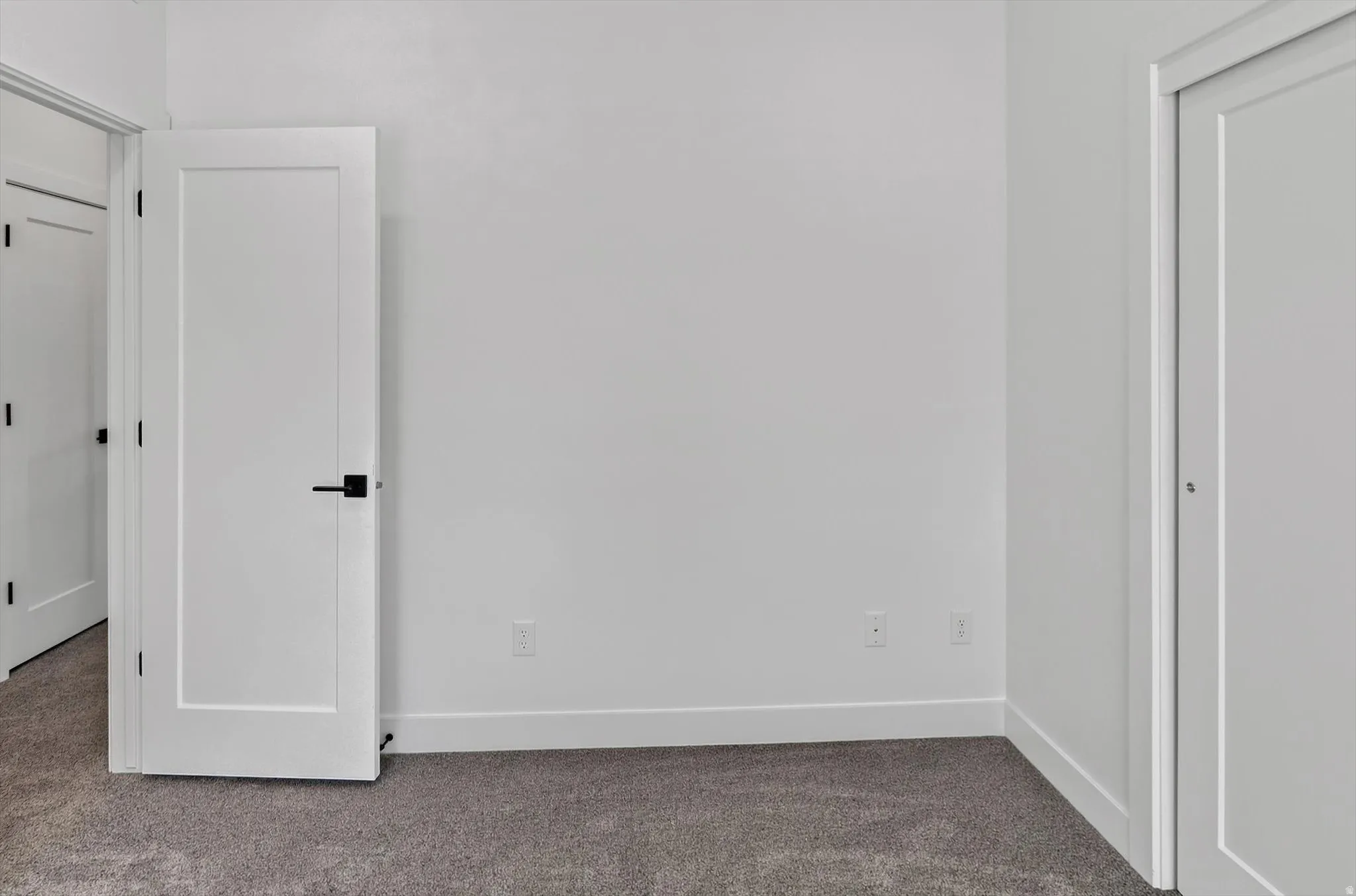 White interior walls with flat panel doors and contemporary matte black hardware