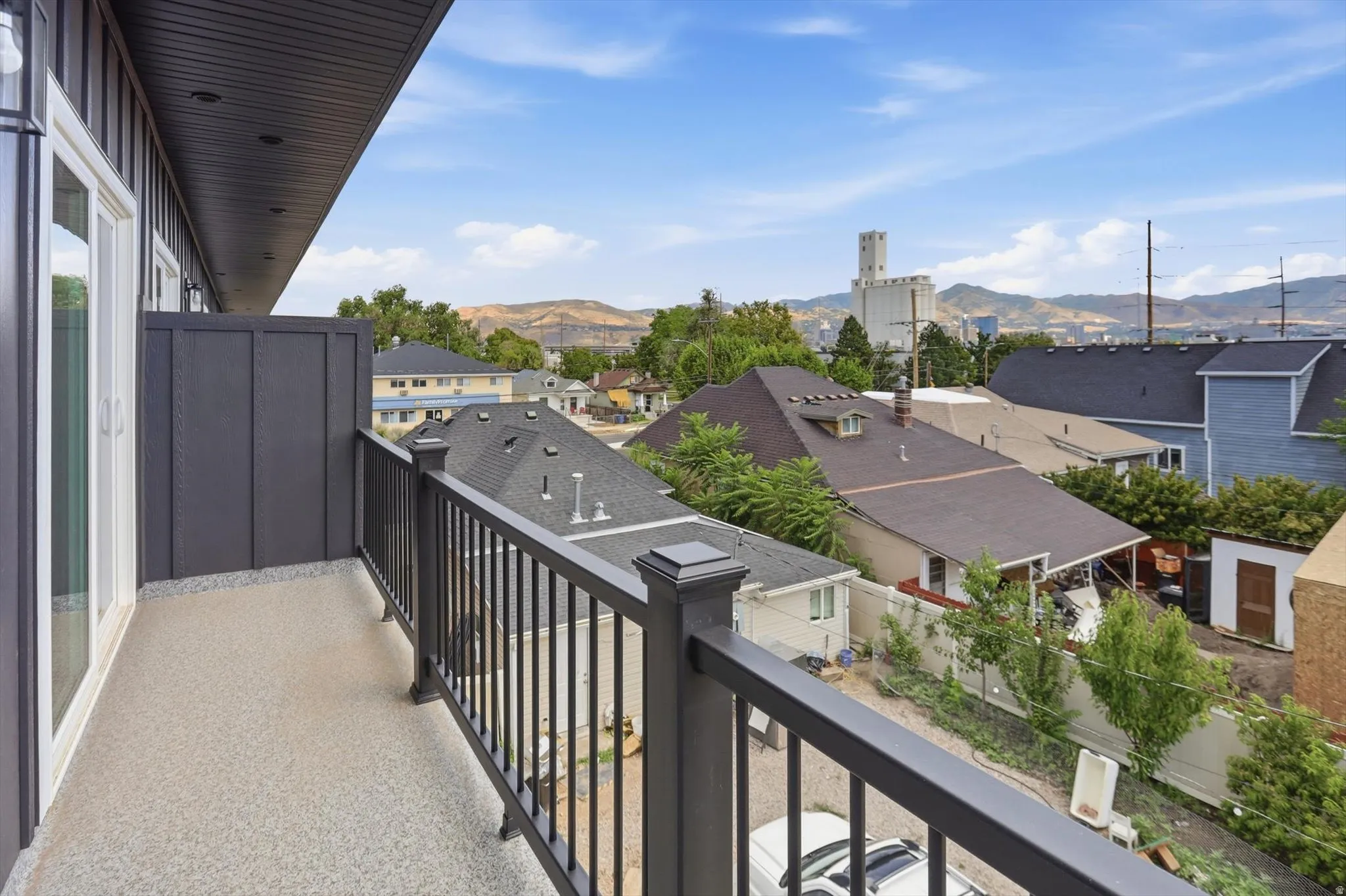 Private balcony with durable speckled flooring and dark metal railings