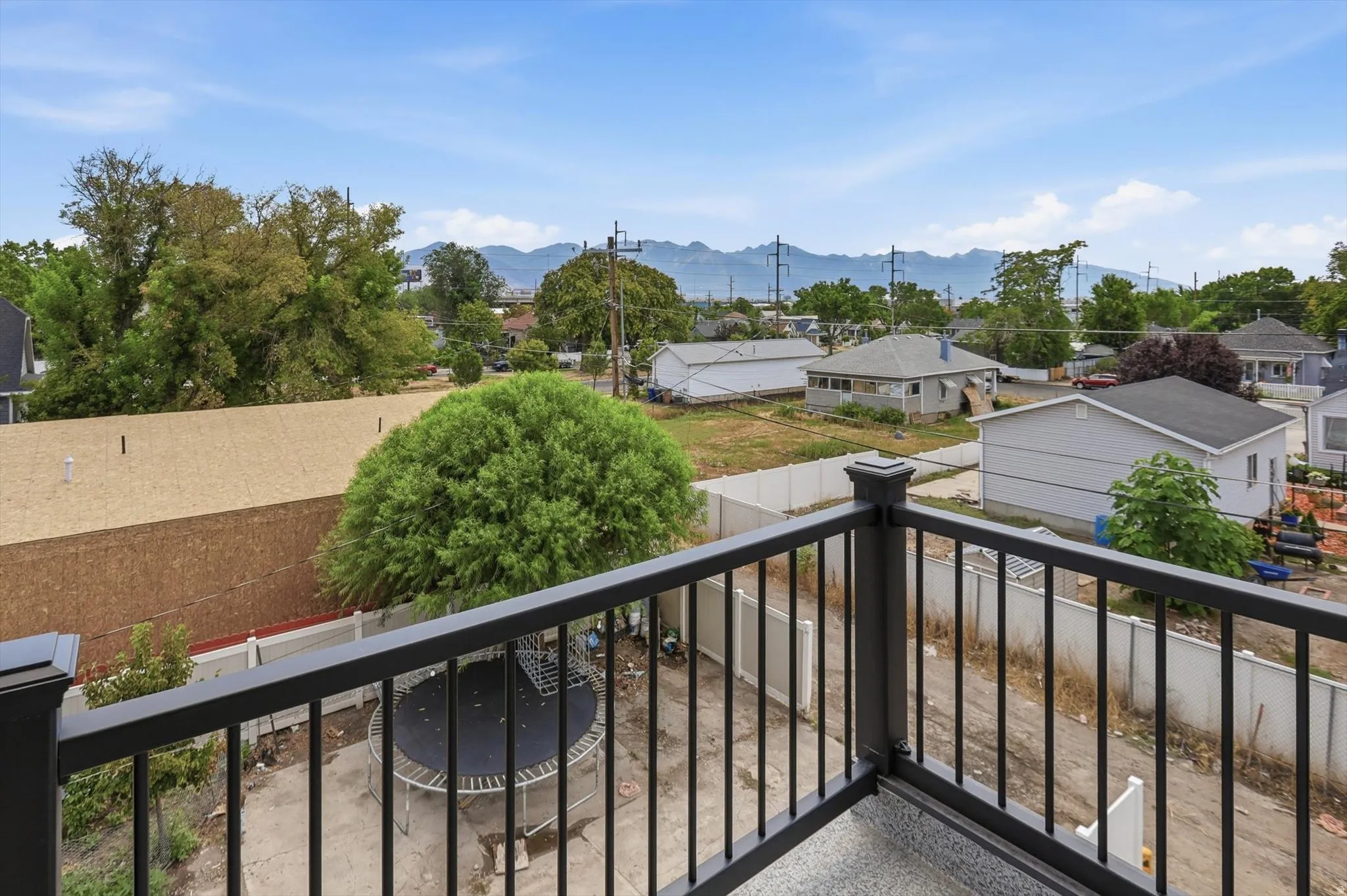 Exterior balcony featuring black metal railings and a grey textured floor