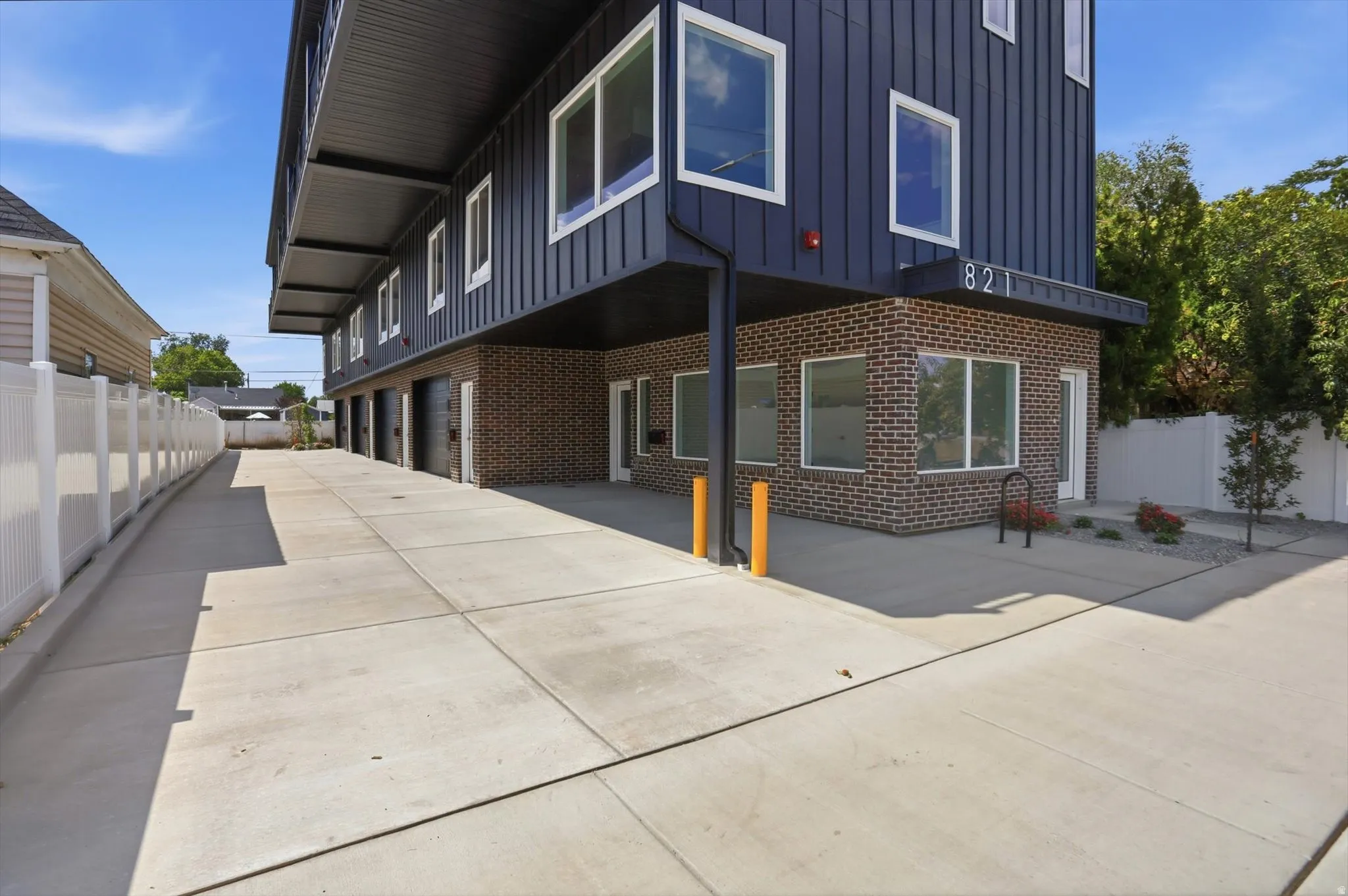 Contemporary building facade featuring dark vertical siding and brick accents