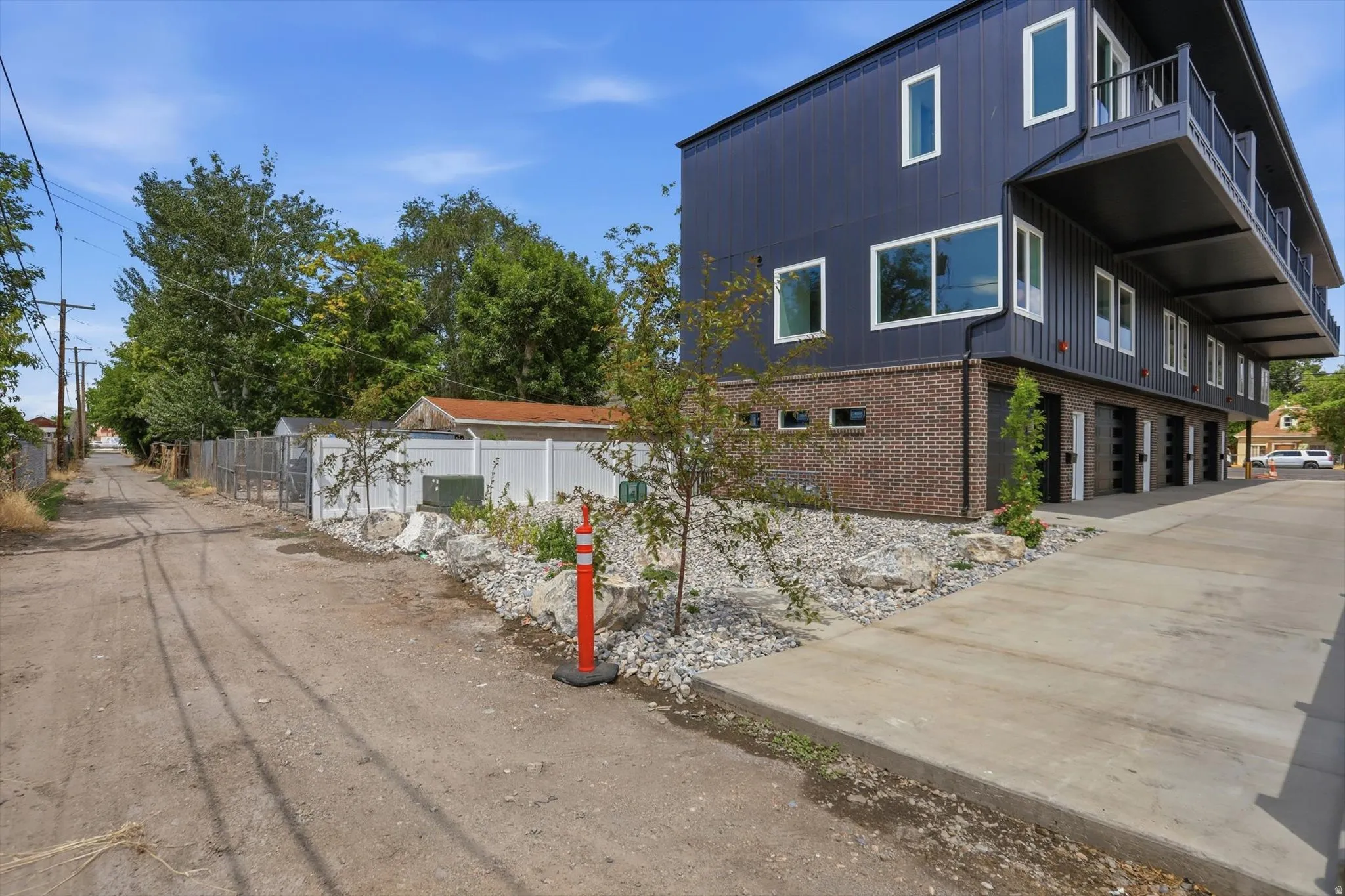 Contemporary multi-story facade featuring dark vertical siding and brick accents