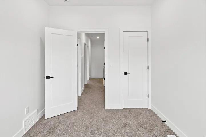 Interior room featuring neutral carpeting and white walls