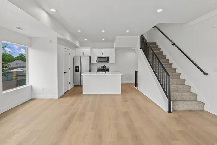 Open-concept living area featuring wood-finish flooring and recessed lighting throughout