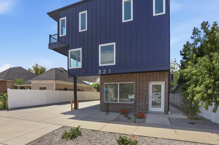 Modern exterior featuring dark blue siding and a brick facade