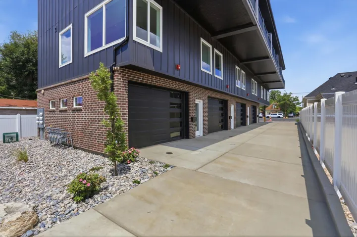 Contemporary multi-story building featuring dark vertical siding and brick accents
