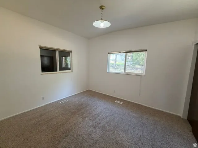 Carpeted interior space featuring white walls and a light fixture