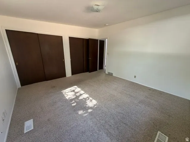 Room with light-toned carpet flooring, white walls, and white baseboards