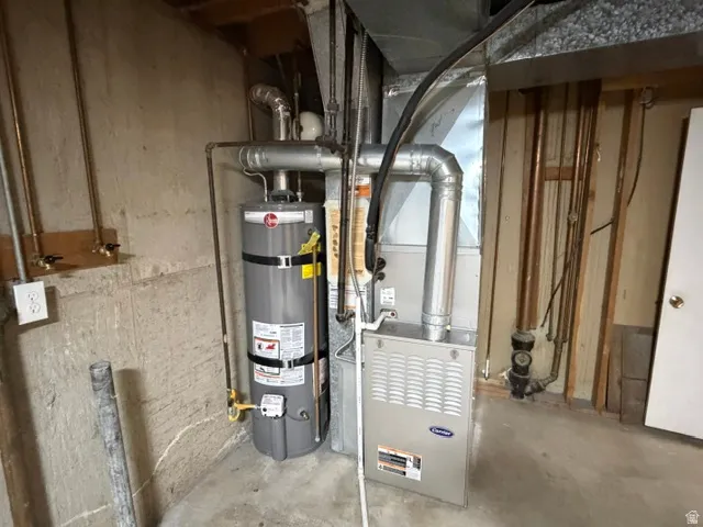 Utility area featuring a Rheem hot water heater and a Carrier furnace