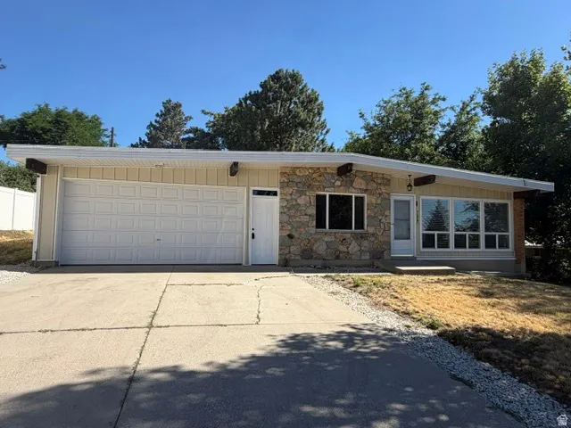 Ranch-style exterior featuring a stone and siding facade