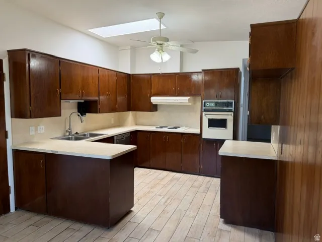 Kitchen featuring extensive dark wood cabinetry and light-toned countertops