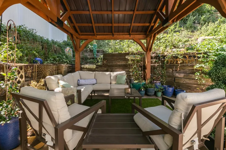 Open-air wooden gazebo featuring a metal roof