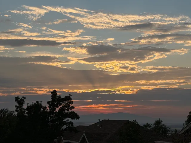 Expansive sky with varied cloud formations and visible light rays