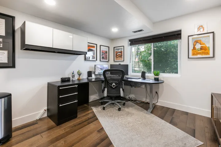 Dedicated office space featuring rich wood-finish flooring and a large window