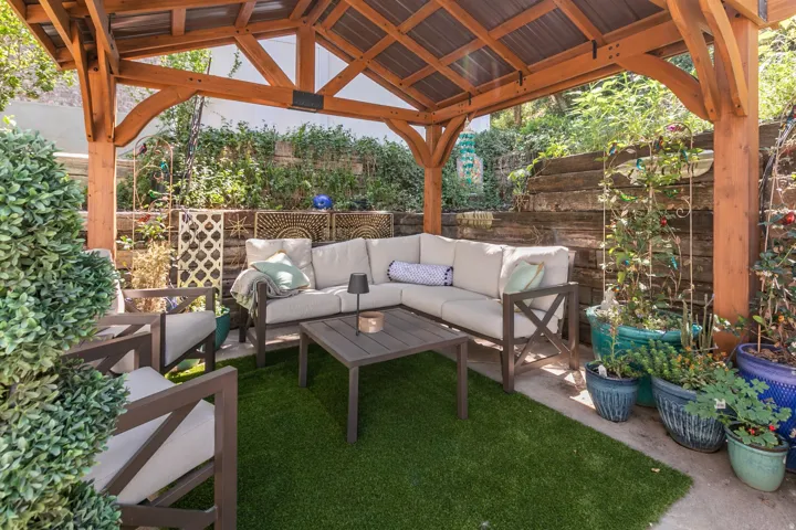 Outdoor living area featuring a wood pergola with a metal roof
