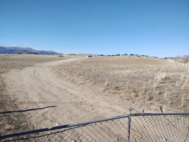 Expansive parcel with a chain-link fence and decorative gate