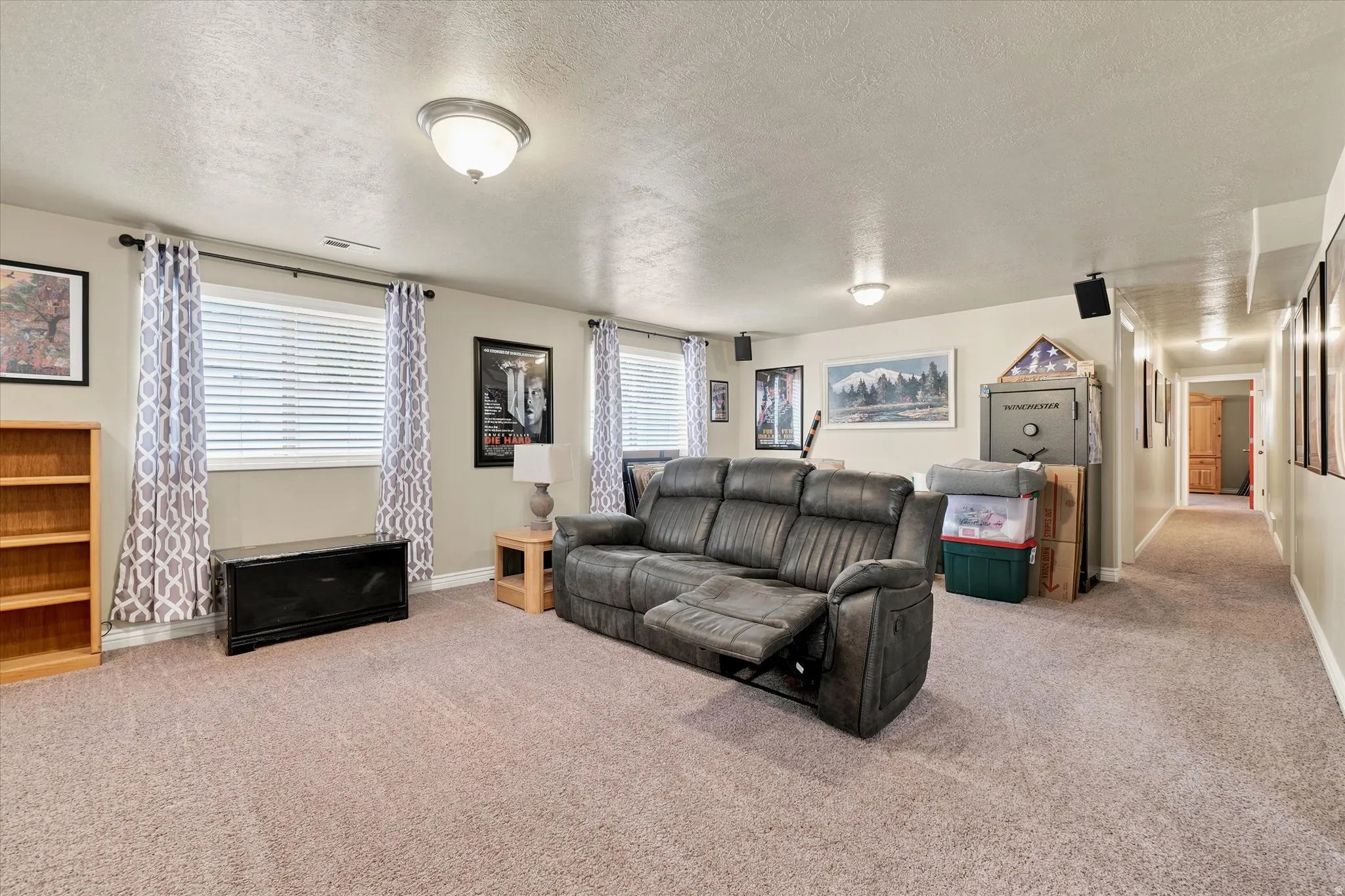 Spacious carpeted room featuring multiple windows with blinds, recessed lighting, and a neutral wall color
