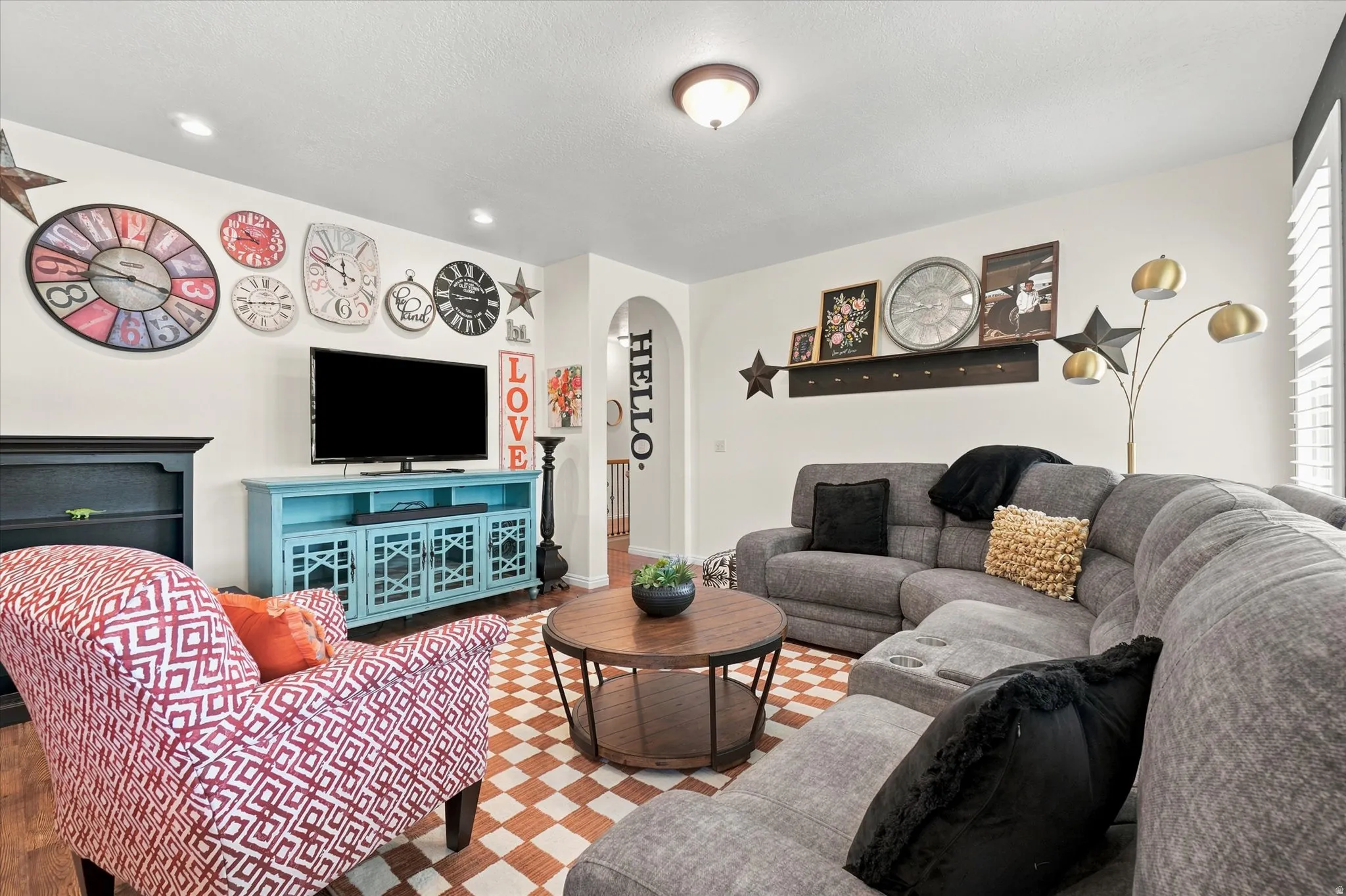 Open-concept living space featuring wood-finish flooring, recessed lighting, and a white color palette