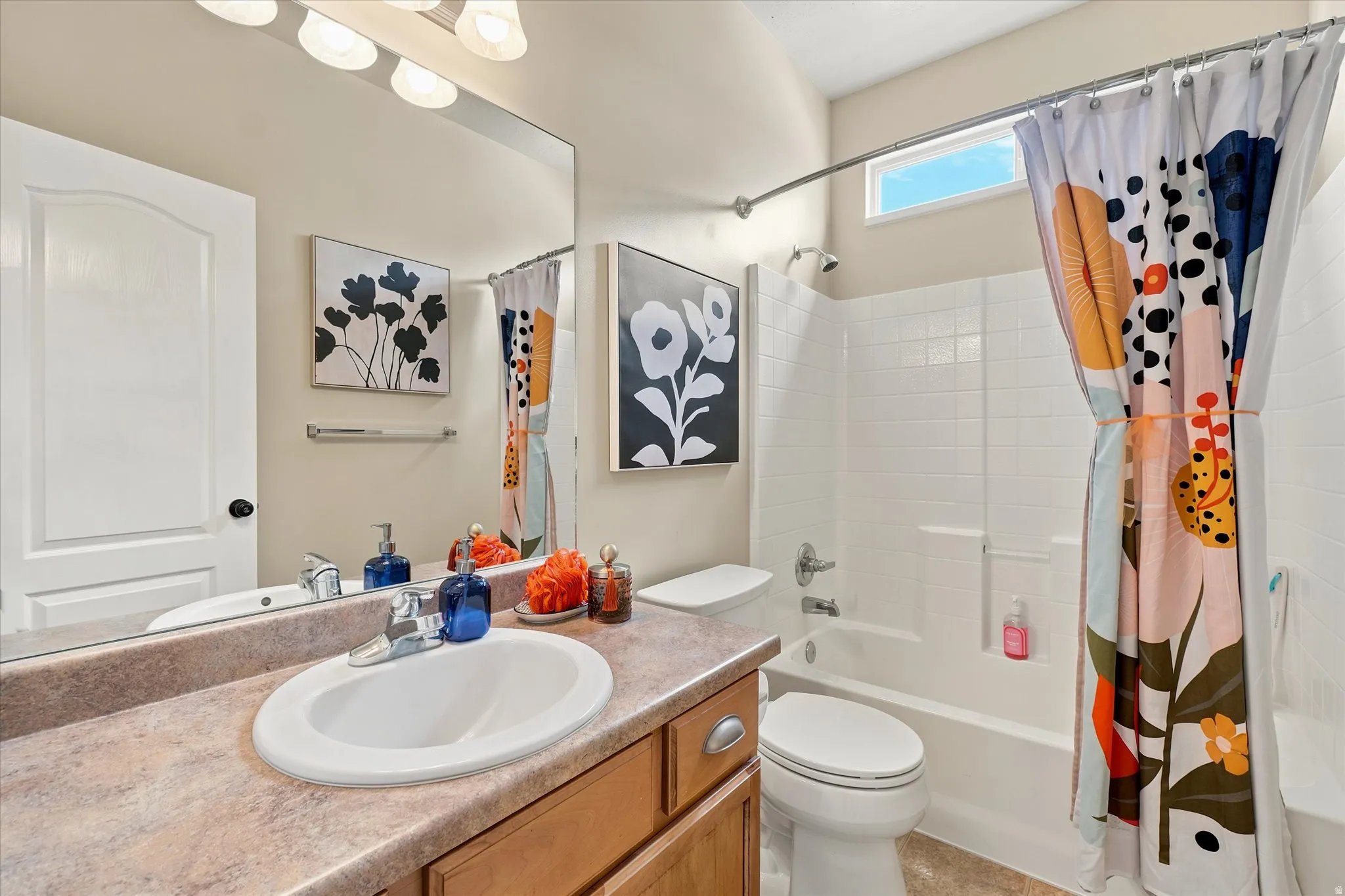 Full bathroom featuring a single vanity with an oval sink, a light-toned countertop, and wood-finish cabinetry