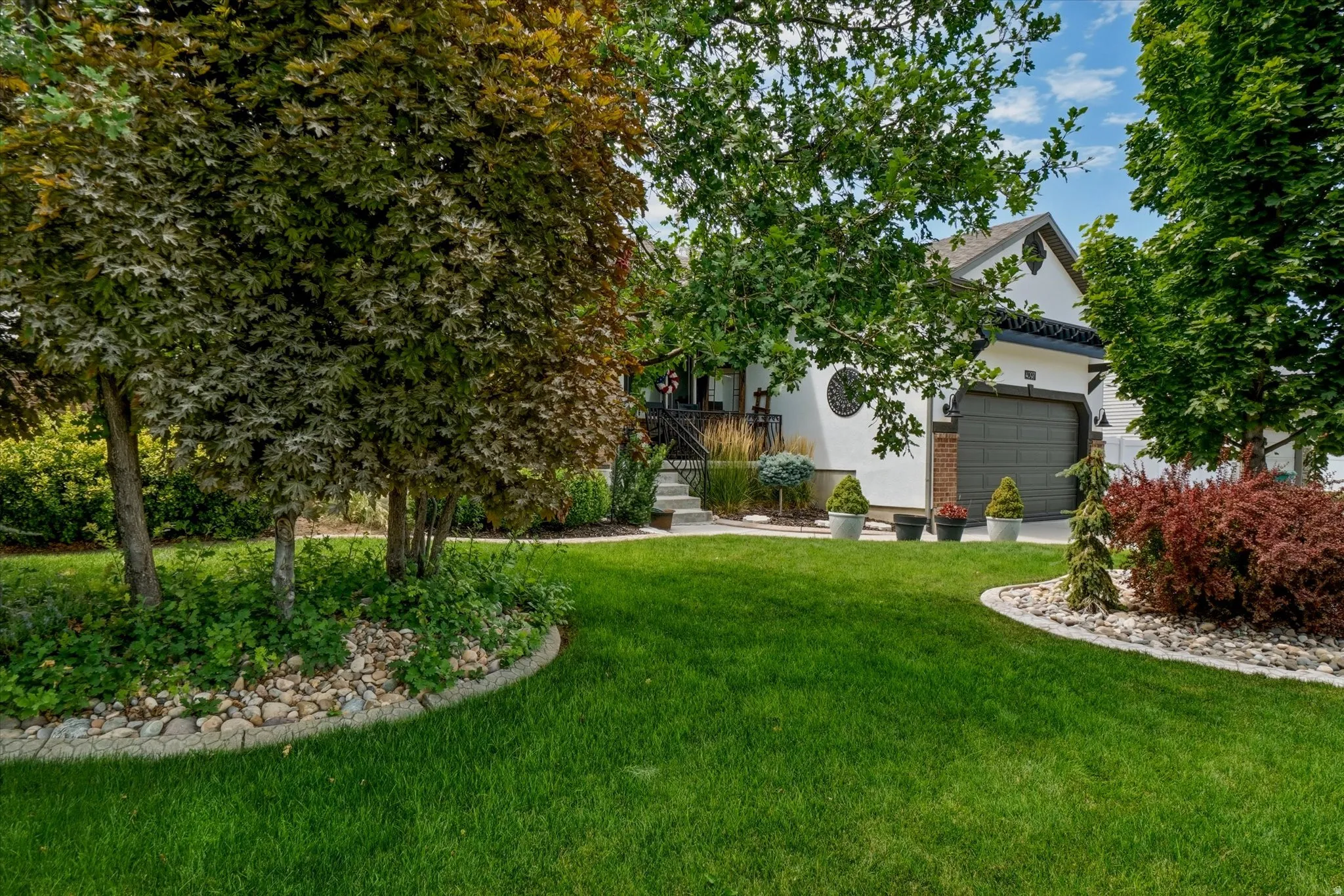 Lush green lawn with mature trees and established landscaping