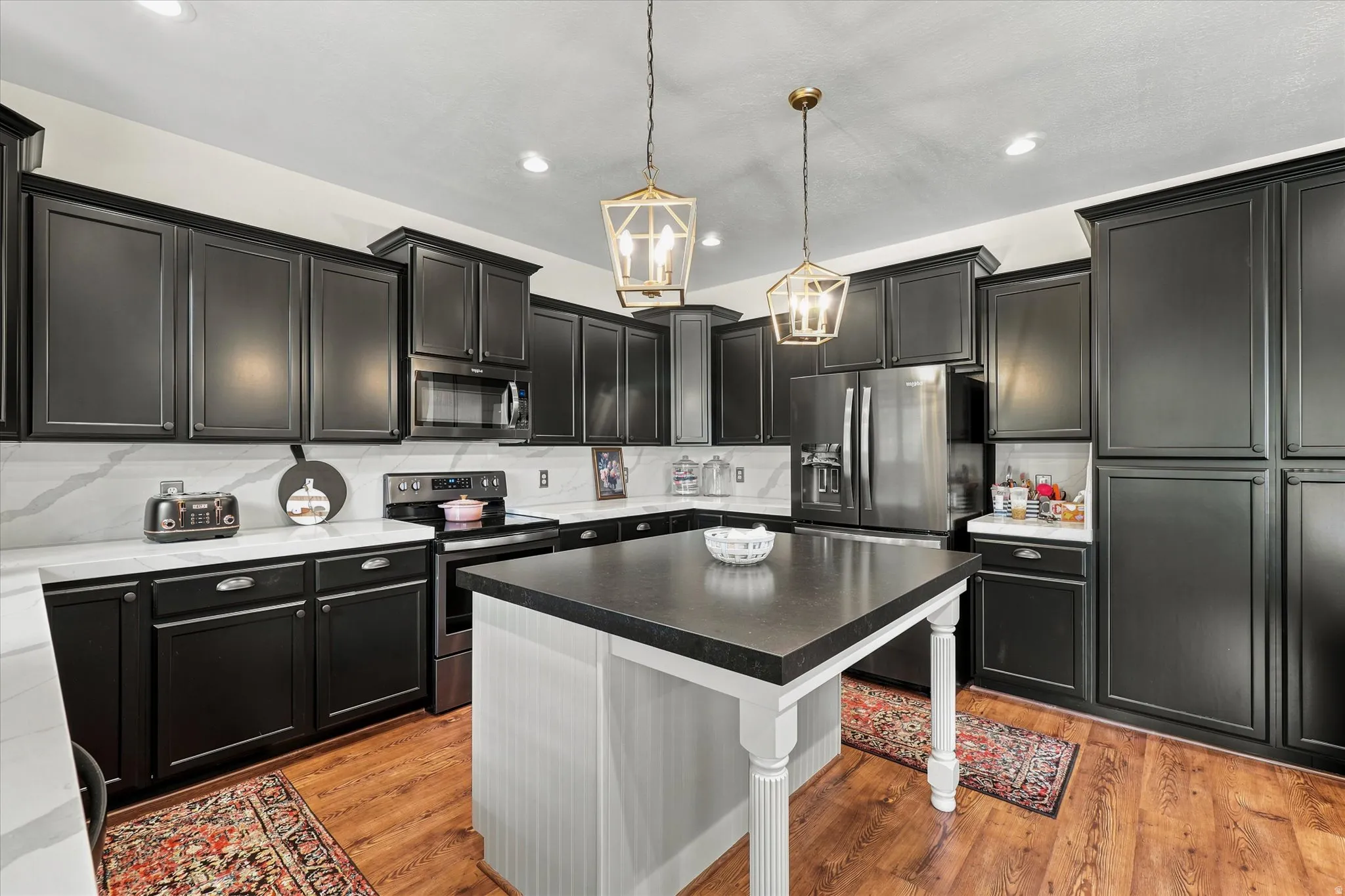 Kitchen featuring dark cabinetry, white countertops, and full-height backsplash