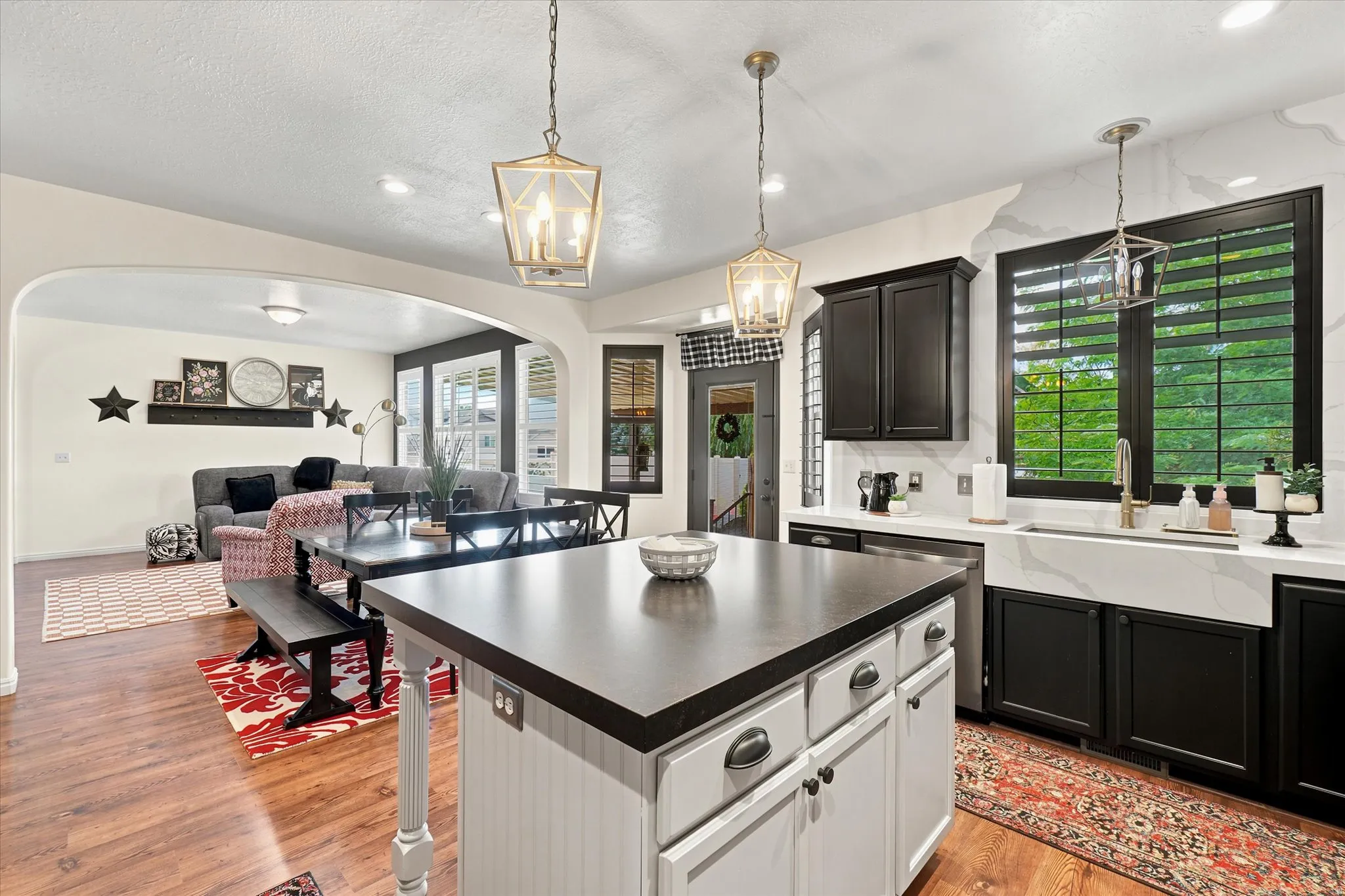 Kitchen featuring a central island with beadboard paneling, dark countertops, and pendant lighting
