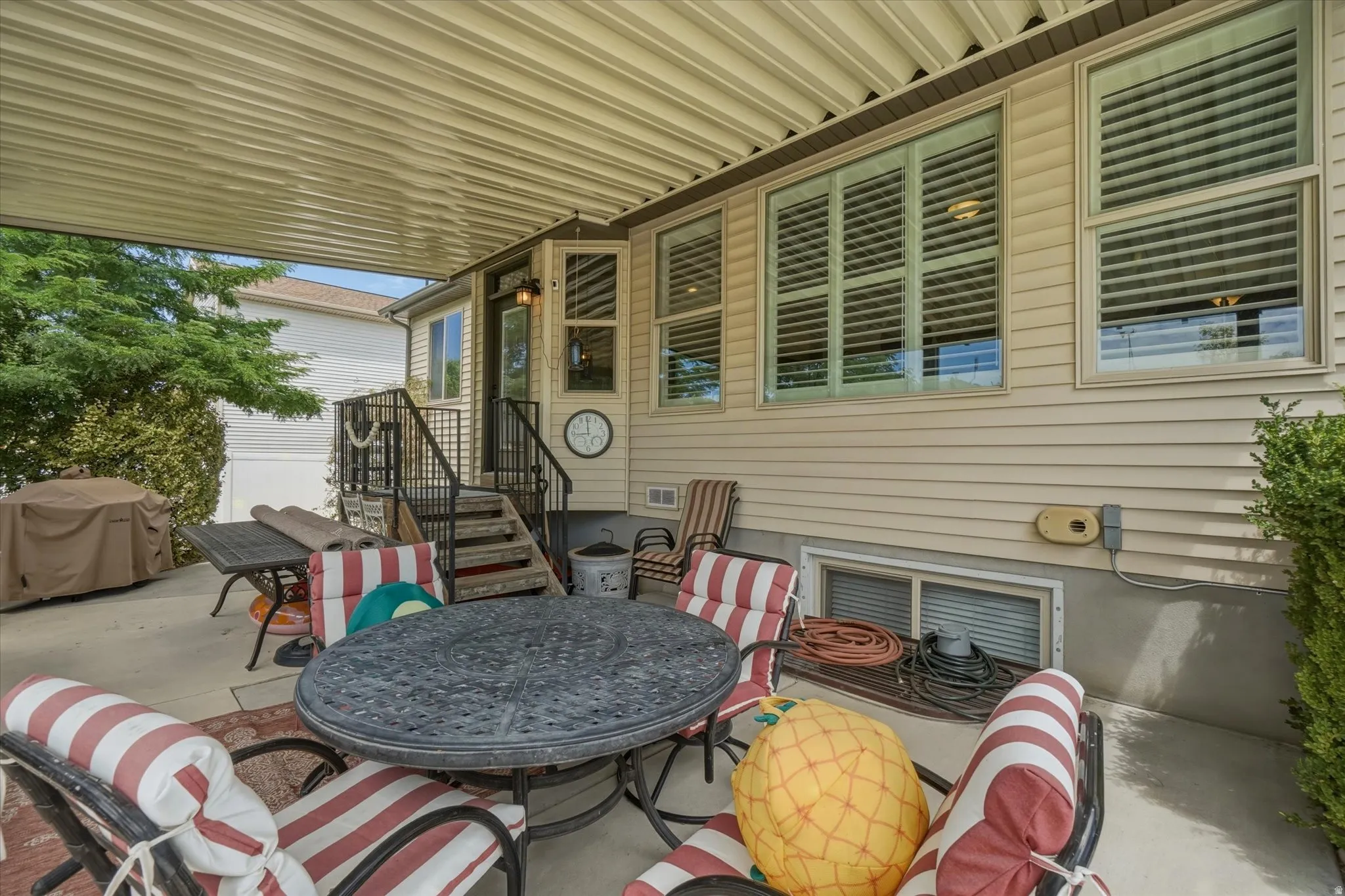 Expansive covered patio featuring a concrete surface, a built-in staircase with metal railings, and a siding exterior