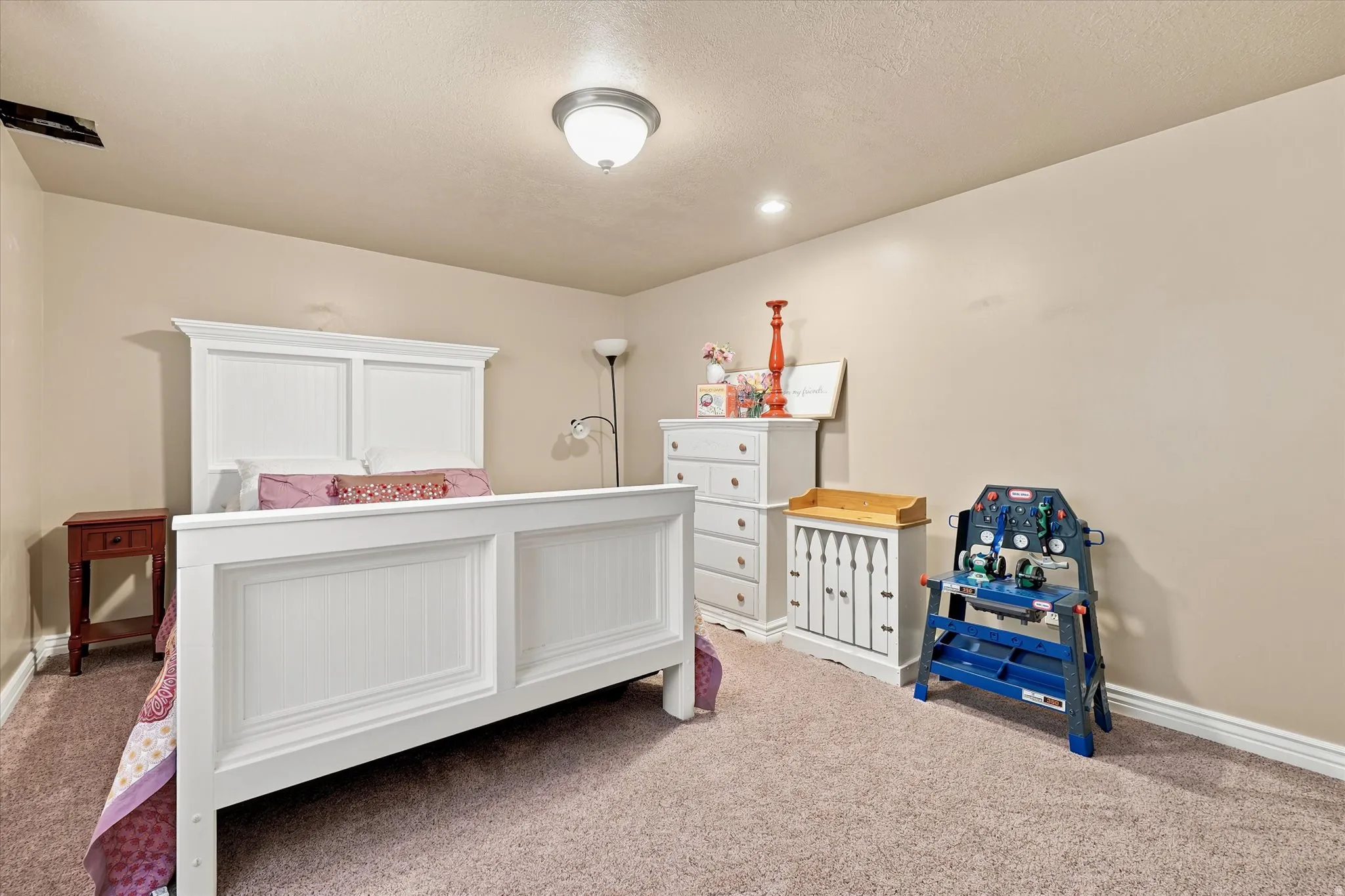 Carpeted bedroom featuring neutral wall paint, a ceiling-mounted light fixture, and a recessed ceiling light