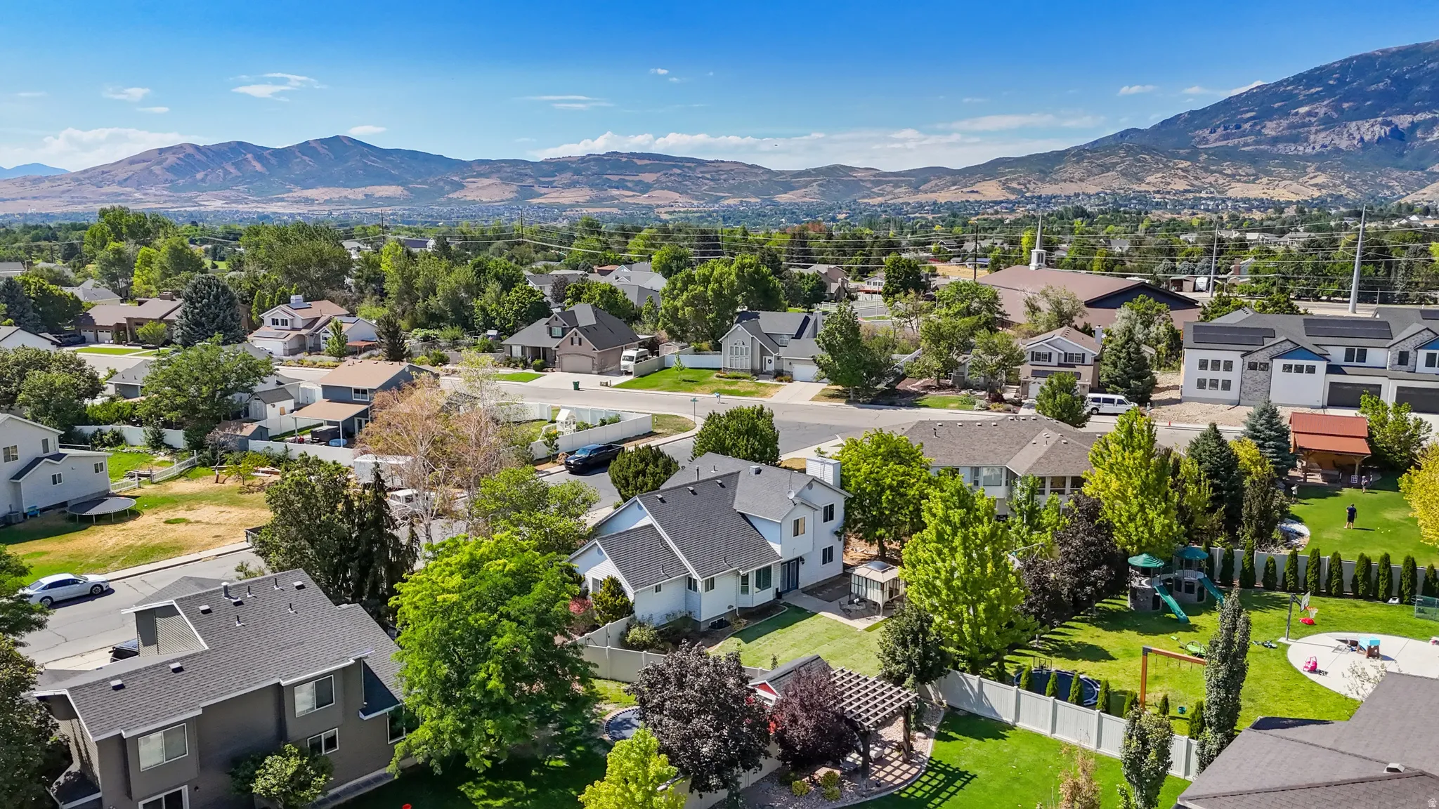 Expansive residential area featuring established homes, mature landscaping, and mountain scenery