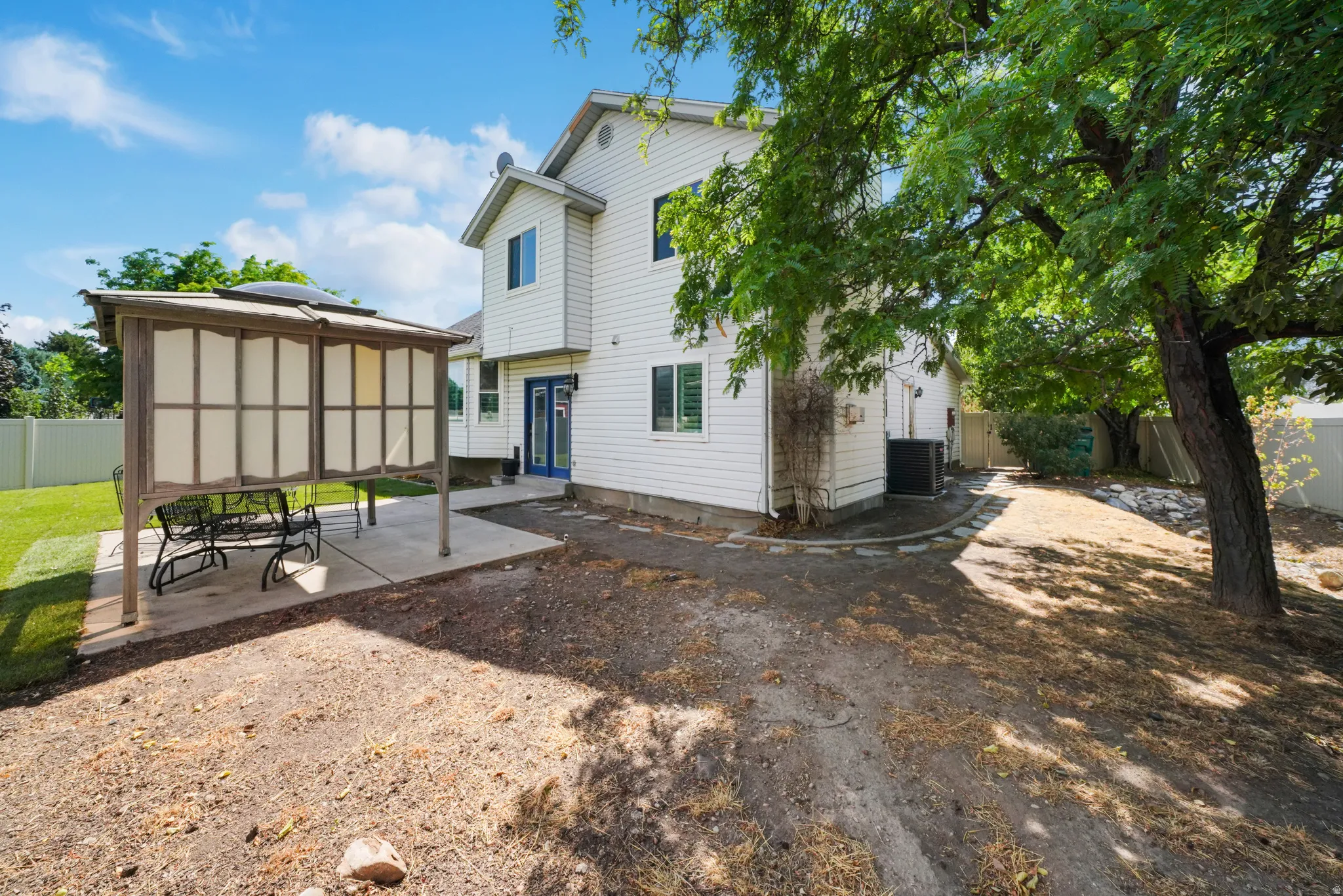 Rear exterior featuring white siding and multiple windows
