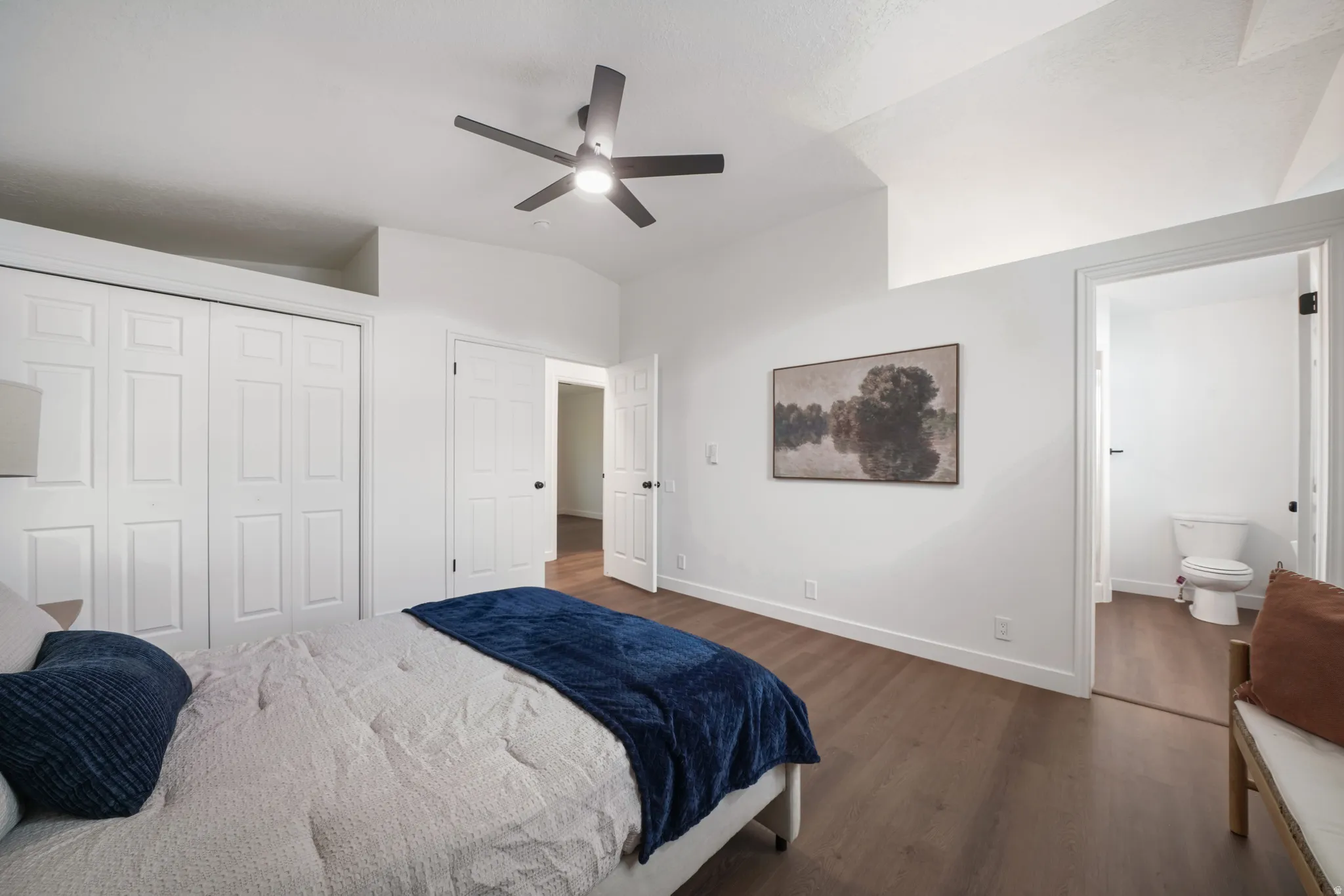 Room featuring wood-finish flooring, a contemporary ceiling fan, and white bi-fold closet doors