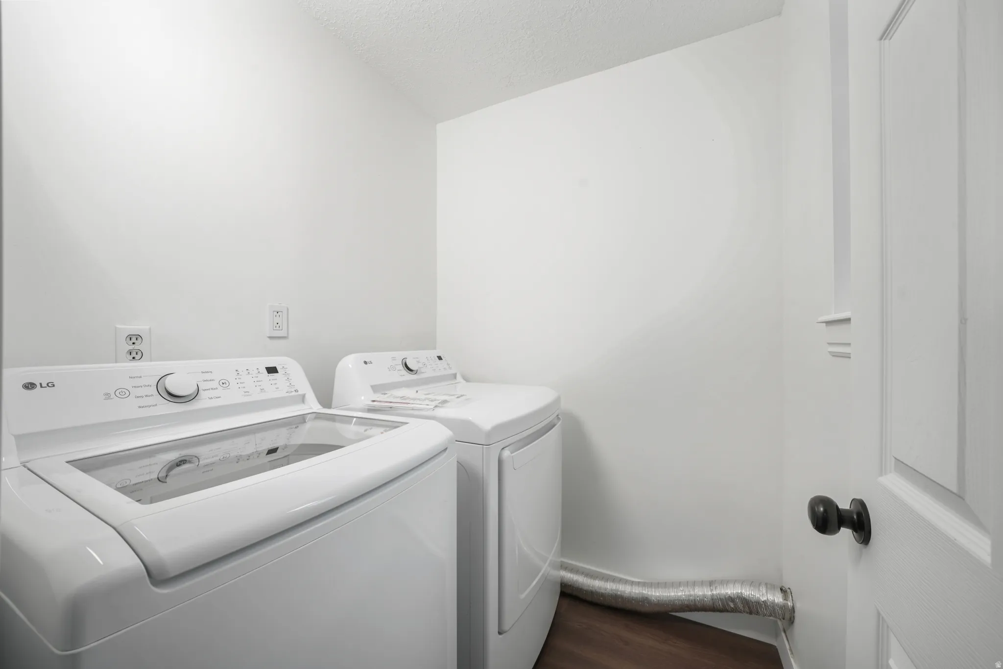Dedicated laundry area featuring wood-finish flooring