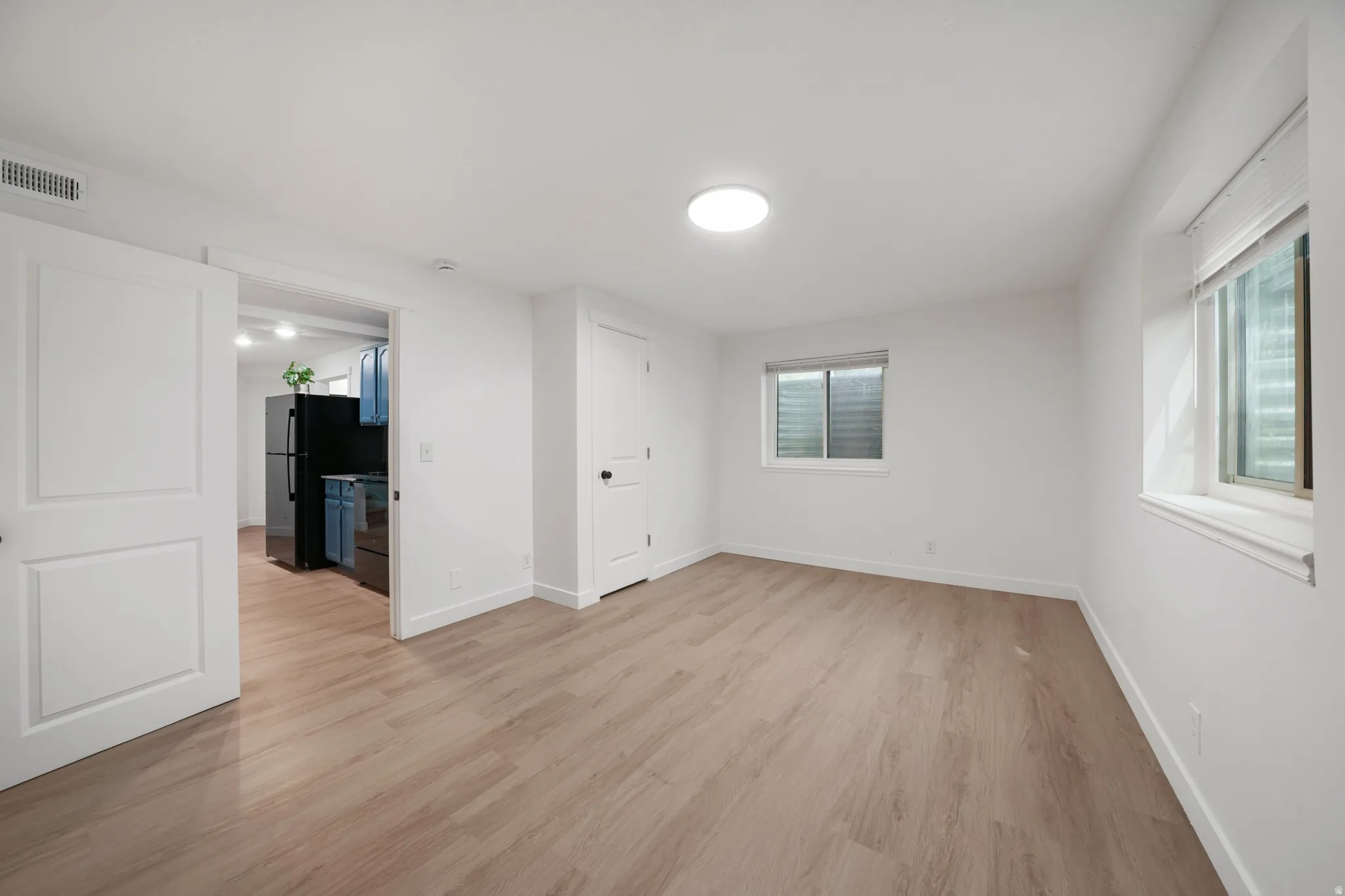 Open-concept living area featuring wood-finish flooring, recessed lighting, and white trim