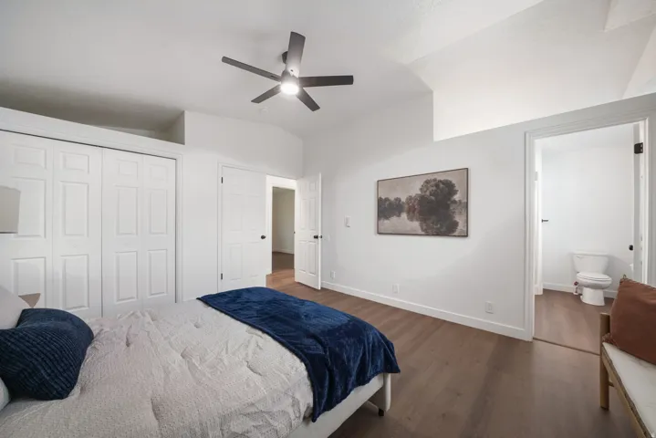 Room featuring wood-finish flooring, a contemporary ceiling fan, and white bi-fold closet doors