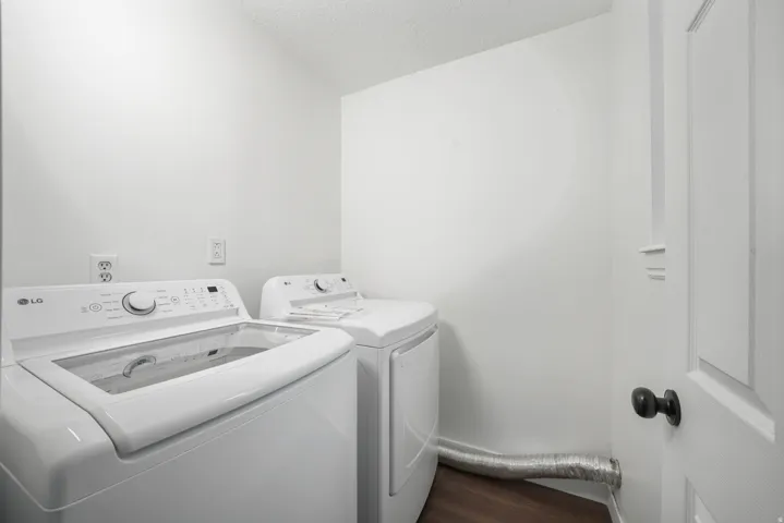 Dedicated laundry area featuring wood-finish flooring
