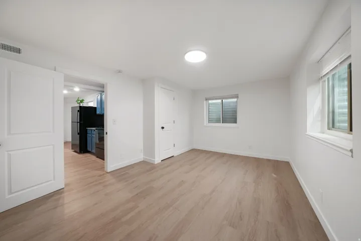 Open-concept living area featuring wood-finish flooring, recessed lighting, and white trim
