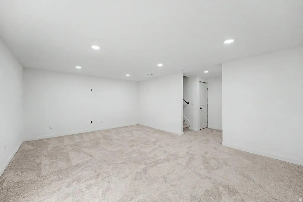 Spacious room featuring neutral carpeting and white walls