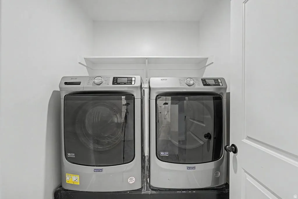 Dedicated laundry area featuring a front-load washer and dryer set