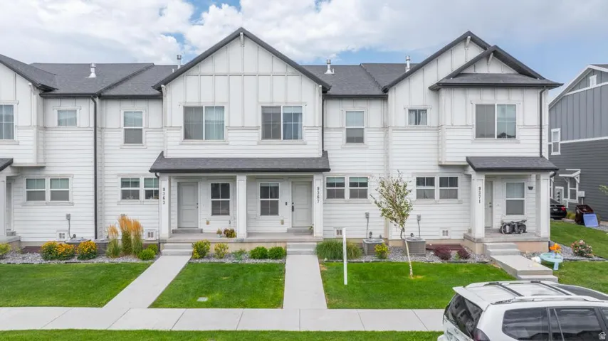 Modern townhome exterior featuring white horizontal siding and vertical board and batten accents