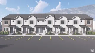 Property Image. Depicting the exterior of a multi-unit residential building and associated parking area