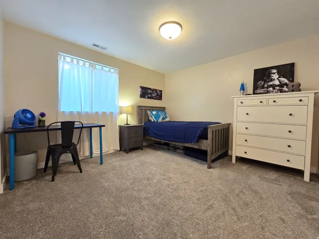 Cream-colored walls complement the light gray carpet flooring