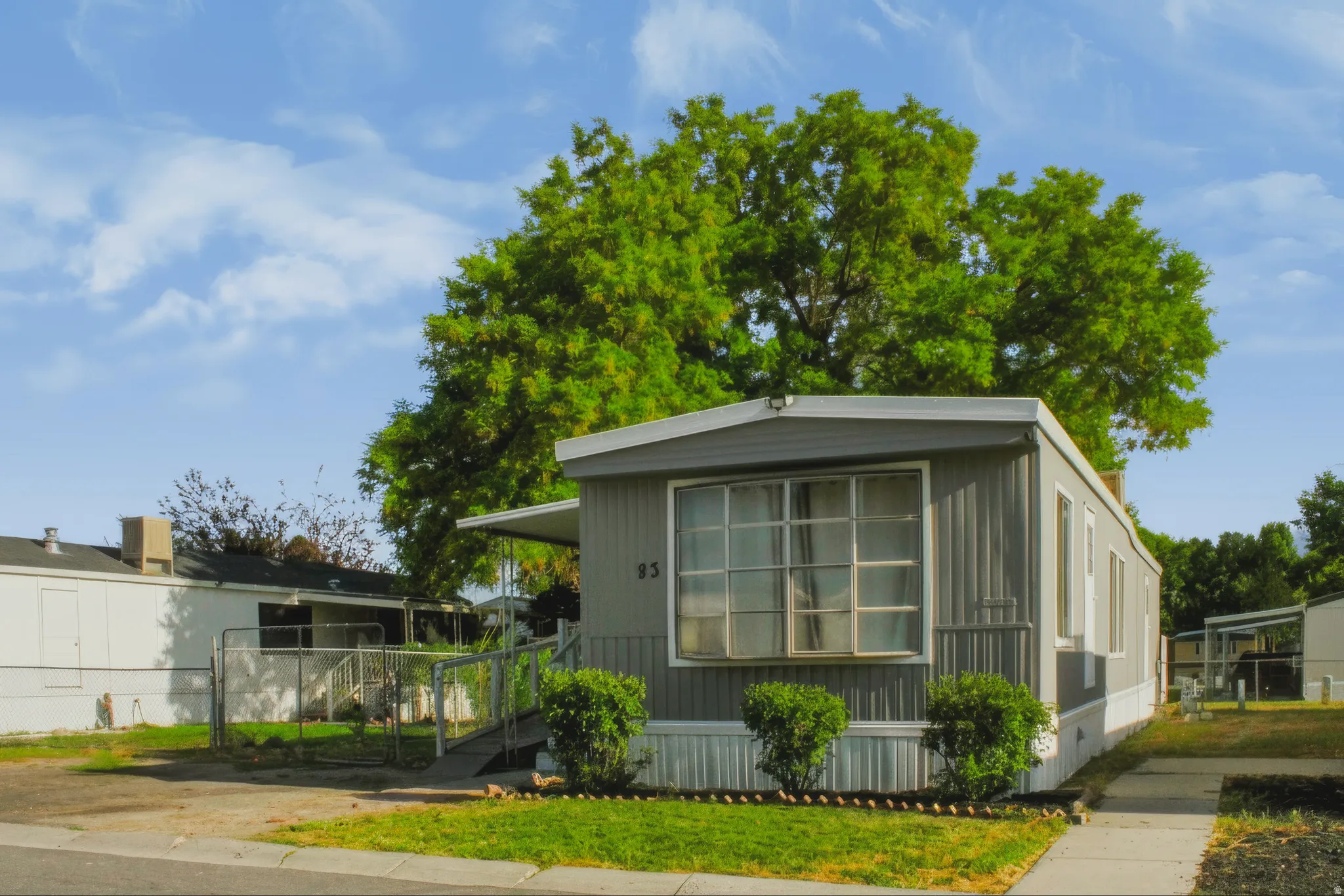 Gray-paneled exterior with white trim and a covered front entry
