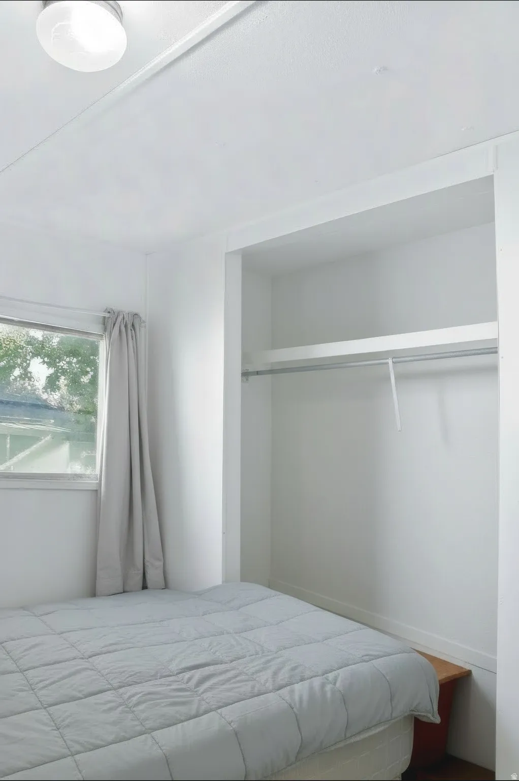 Bedroom with a built-in closet featuring a hanging rod and shelving