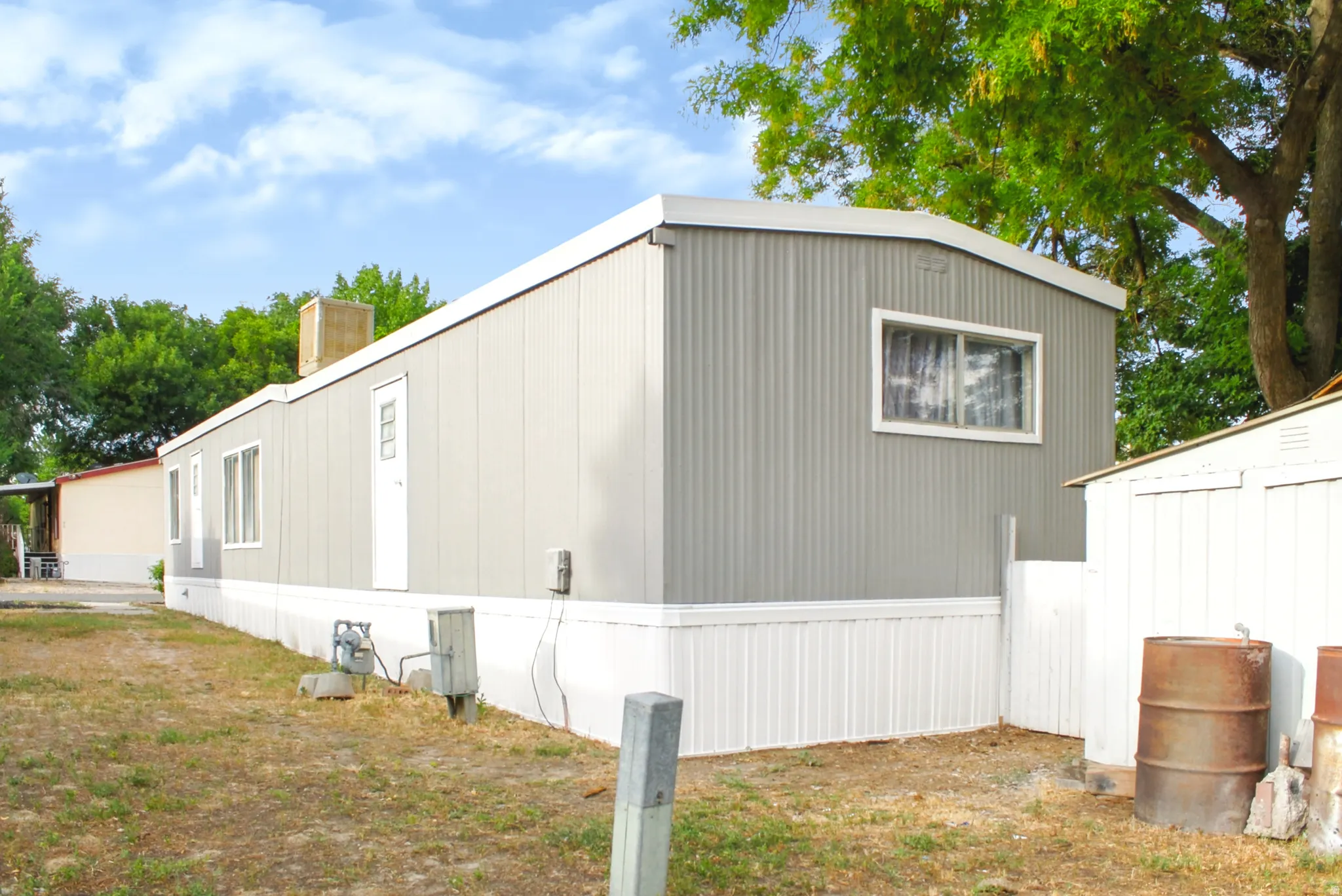 Gray corrugated siding exterior with white trim and a white entrance door
