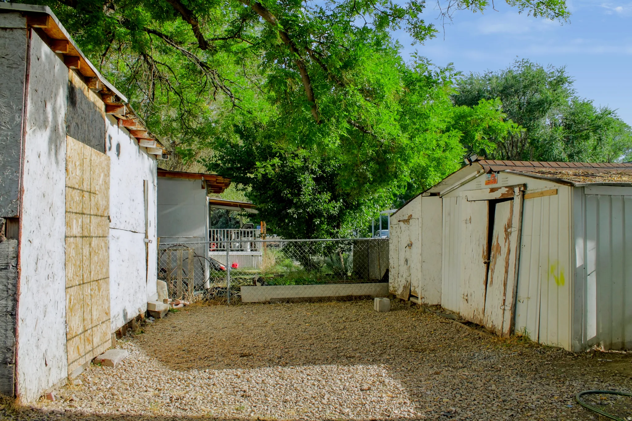 Gravel lot with 4 sheds 2 on each side.