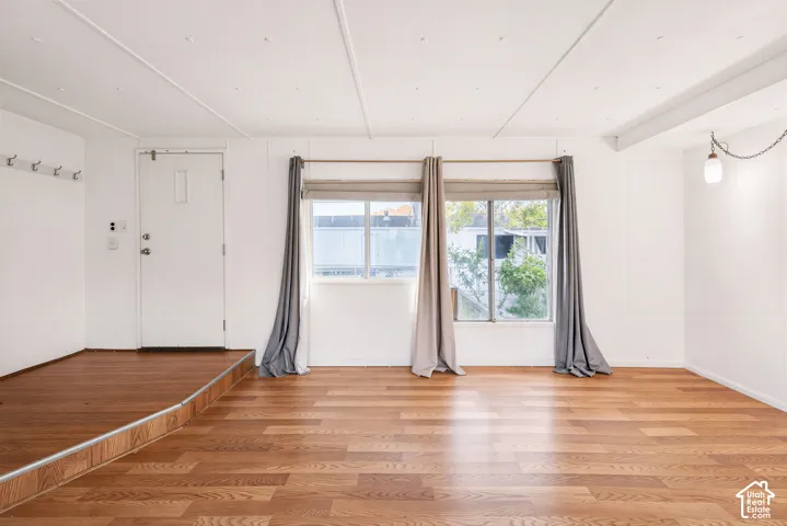 Wood-finish flooring throughout, multiple windows, recessed lighting, and a suspended ceiling fixture